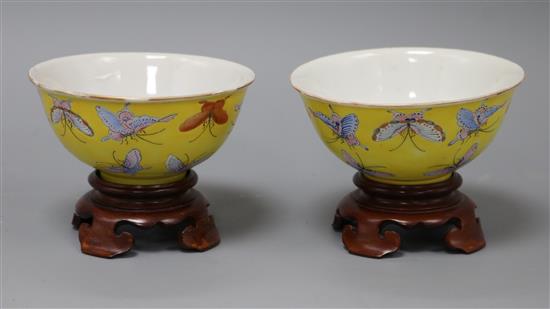 A pair of Chinese Tongzhi yellow ground butterfly bowls, wood stands diameter 11cm
